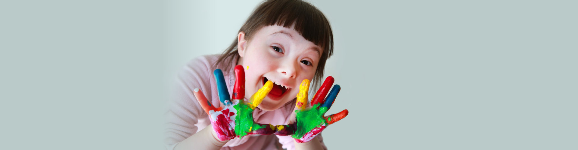 smiling child with painted hands.